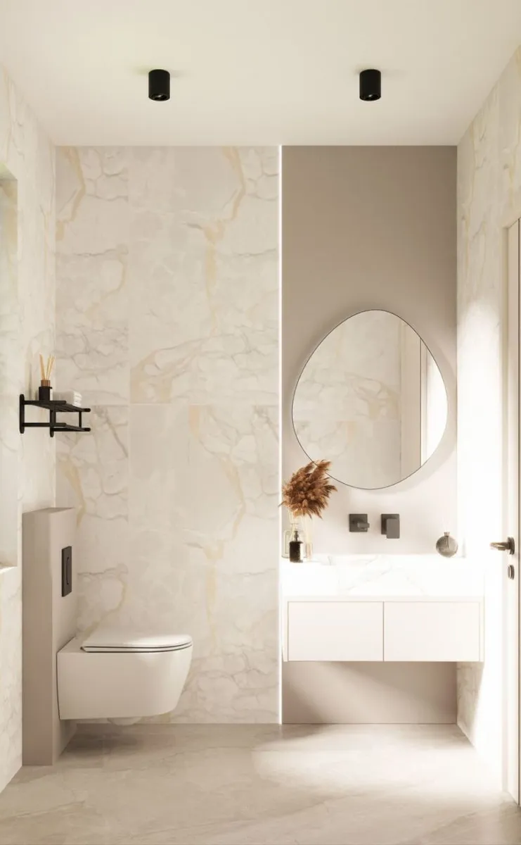 Bathroom with marble walls and oval mirror